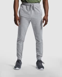 Grey track pants with an elastic waistband and side pockets, featuring an emblem on the hip.