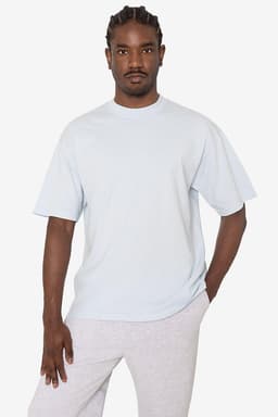 A light blue short sleeve crewneck tee with a relaxed fit, featuring a logo on the side.