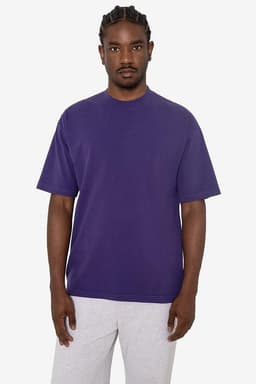 A purple short sleeve crewneck tee displayed on a model, featuring a relaxed fit and no visible logos.