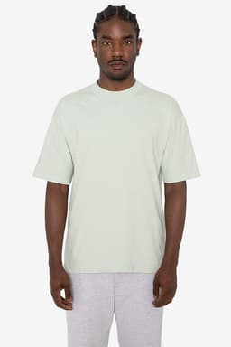 A light green short sleeve crewneck t-shirt displayed on a model, featuring a simple design and a logo.