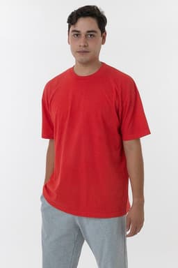 A red short sleeve crewneck tee displayed on a model, paired with grey trousers. The shirt has a logo.