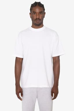 A white short sleeve crewneck tee, featuring a relaxed fit and a logo on the front. The model wears grey shorts.