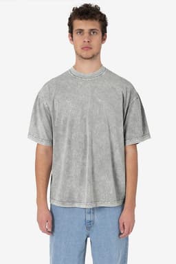 A man wearing a grey short sleeve mineral wash crew tee, styled with loose jeans. The shirt has a simple design and visible stitching.
