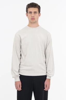 A long sleeve crewneck tee in a light grey colour, featuring a relaxed fit and a simple logo.
