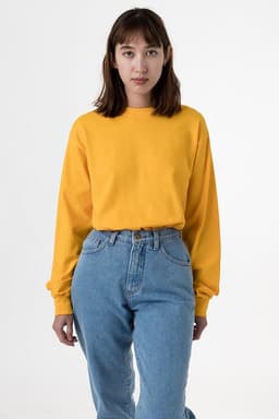 A yellow long sleeve crewneck tee worn with high-waisted blue jeans. The shirt has a logo on it.