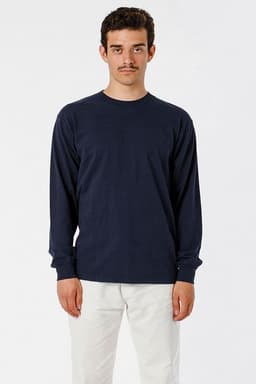 A long sleeve crewneck tee in navy blue, displayed on a model wearing light coloured trousers, featuring a logo.