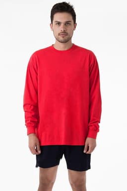 A man wearing a bright red long sleeve crewneck tee, paired with dark shorts, standing against a plain background.