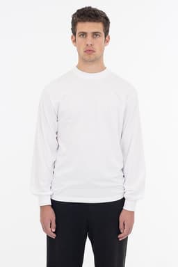A long sleeve crewneck tee in white, featuring a minimalistic design and a fitted silhouette.