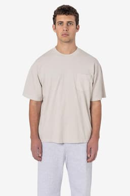 A short sleeve garment-dyed pocket tee in beige, displayed worn by a model with grey sweatpants.