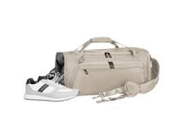 A beige duffle bag with multiple zippered compartments and a detachable strap, accompanied by a pair of white and grey sneakers.