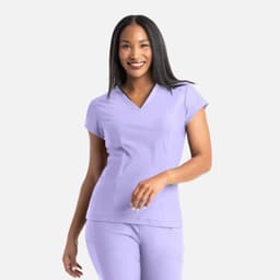 A woman wearing a lavender banded V-neck top. The top has short sleeves and a simple design.