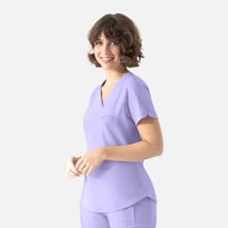 A light purple tuckable Y-neck top with short sleeves, featuring a pocket and a branding logo.