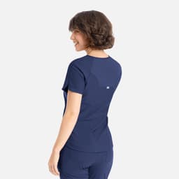 A navy blue Y-neck top with short sleeves and a slightly relaxed fit, featuring a logo on the back.