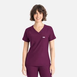 A woman is wearing a plum-coloured Y-neck top with short sleeves and a small logo on the chest.