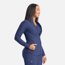 A full zip track jacket in navy blue, featuring a sleek design and a side pocket, worn by a smiling model.