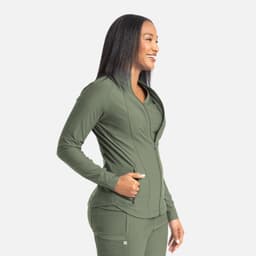 A full zip track jacket in olive green, featuring a sleek design and a logo. The model is smiling while posing.