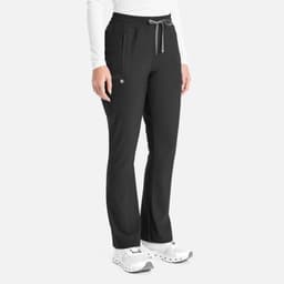 A pair of black bootcut pants with a drawstring waistband and side pockets. The model stands wearing white shoes.