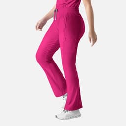 A pair of bright pink bootcut pants with an elastic waistband and side pockets. The pants have a logo on them.