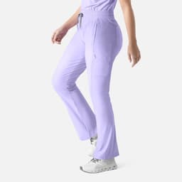 A pair of lilac bootcut pants featuring an elastic waistband and pockets. The pants have a logo on them.