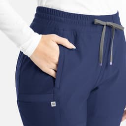 A blue bootcut pant with an elastic waistband and pockets, featuring subtle branding on the side.