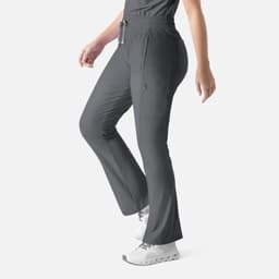 A grey bootcut pant with a drawstring waist and side pockets, displayed on a model. Features a logo on the waistband.