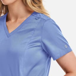A blue women's double V-neck top featuring short sleeves and a subtle logo on the sleeve.