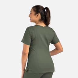 A woman wearing an olive green double V-neck top, showcasing the back design of the garment.