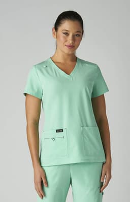 A mint green medical top with a V-neck design and two front pockets, worn by a model. It features a logo.