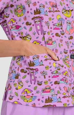 A vibrant purple top featuring a playful print with various whimsical characters and designs, including flowers and animals.