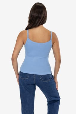 A fitted baby rib spaghetti tank top in light blue, displayed on a model with long hair, paired with denim jeans.