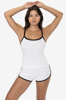 A white spaghetti tank top with black trim, displayed on a model with arms raised.