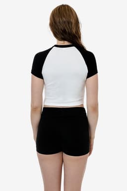 A black and white short sleeve baby rib raglan tee with a fitted design, displayed from the back.