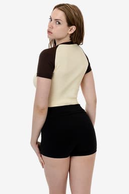 A short sleeve baby rib raglan tee in cream and brown, paired with black shorts, displayed from the back.