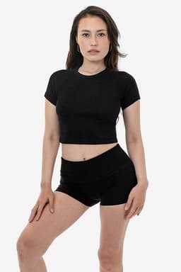 A black short sleeve ribbed tee paired with black shorts, modelled by a female. The top has a fitted design.