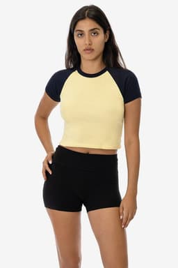 A light yellow short sleeve baby rib raglan tee with navy blue sleeves, paired with black shorts.
