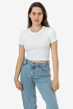 A white mid-length baby rib crewneck tee on a model, paired with blue jeans. The tee has a logo on it.