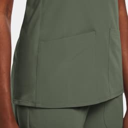 A green women's mock wrap top featuring two front pockets and a sleek design. The top has a subtle branding detail.