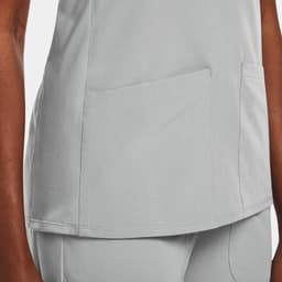 A women's mock wrap top in light grey with two front pockets and a sleek design.