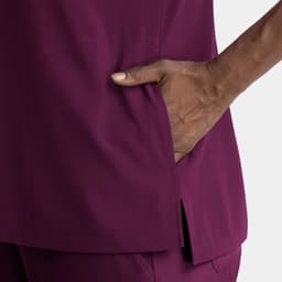 A close-up of a women's top in deep purple, featuring a notched neck and a side pocket.
