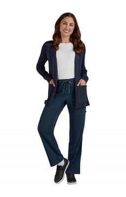 A woman wearing a navy Kori Sweater over a white top, paired with teal pants and sneakers.