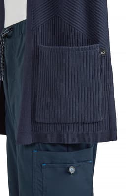 A navy Kori Sweater featuring ribbed textures and a large front pocket, with a branding logo.