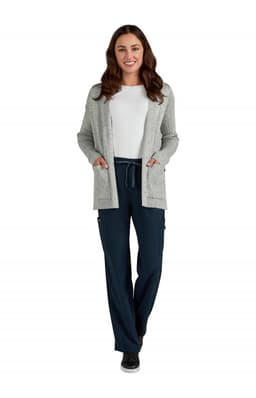 A woman wearing a grey Kori Sweater over a white top, paired with navy pants and black shoes.