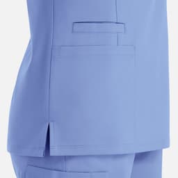 A garment in light blue with a double V-neck design and a side pocket detail. Features a logo on the fabric.