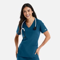A woman wearing a teal women's double V-neck top with a stethoscope around her neck, featuring pockets and a logo.
