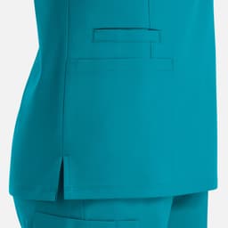 A teal women's double v-neck top featuring a side slit and a pocket. The fabric appears smooth and lightweight.