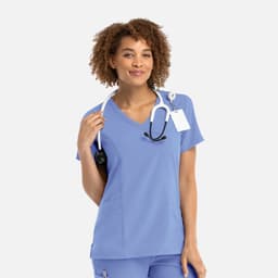 A women's mock wrap top in light blue, featuring a V-neckline and a stethoscope draped around the neck.