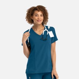 A women's mock wrap top in teal with a stethoscope around the neck and a logo on the chest.