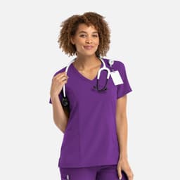 A woman wearing a purple mock wrap top with a stethoscope around her neck. The top features a logo.