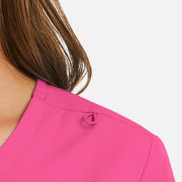A close-up of a women's mock wrap top in bright pink, featuring a detail on the shoulder.