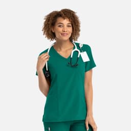 A women's mock wrap top in a vibrant teal colour with a stethoscope around the neck and a tag attached.